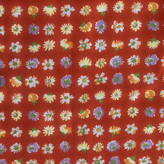 Pattern of colorful flowers on a red reusable beeswax food wrap