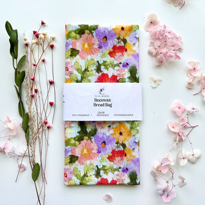 Beeswax bread bag with multicolour floral design on a white background with flowers and leaves.
