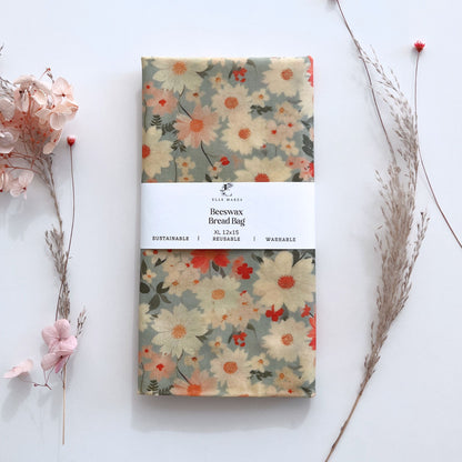 white and pink floral daisy patterned light blue beeswax bread bag with a label on a white background