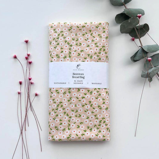Floral-patterned bread bag with white flowers and bread on a white surface