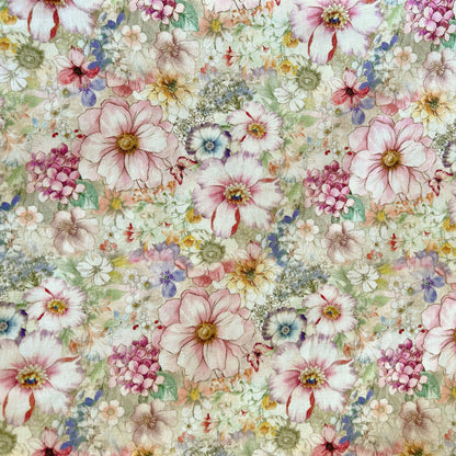 A close-up of a floral pink reusable beeswax food wrap pattern featuring large pale pink flowers, smaller white blossoms, pink berry-like clusters, and soft green and blue accents on a light cream background.