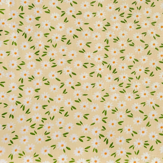 Pattern of small white daisies with green leaves on a beige beeswax wrap
